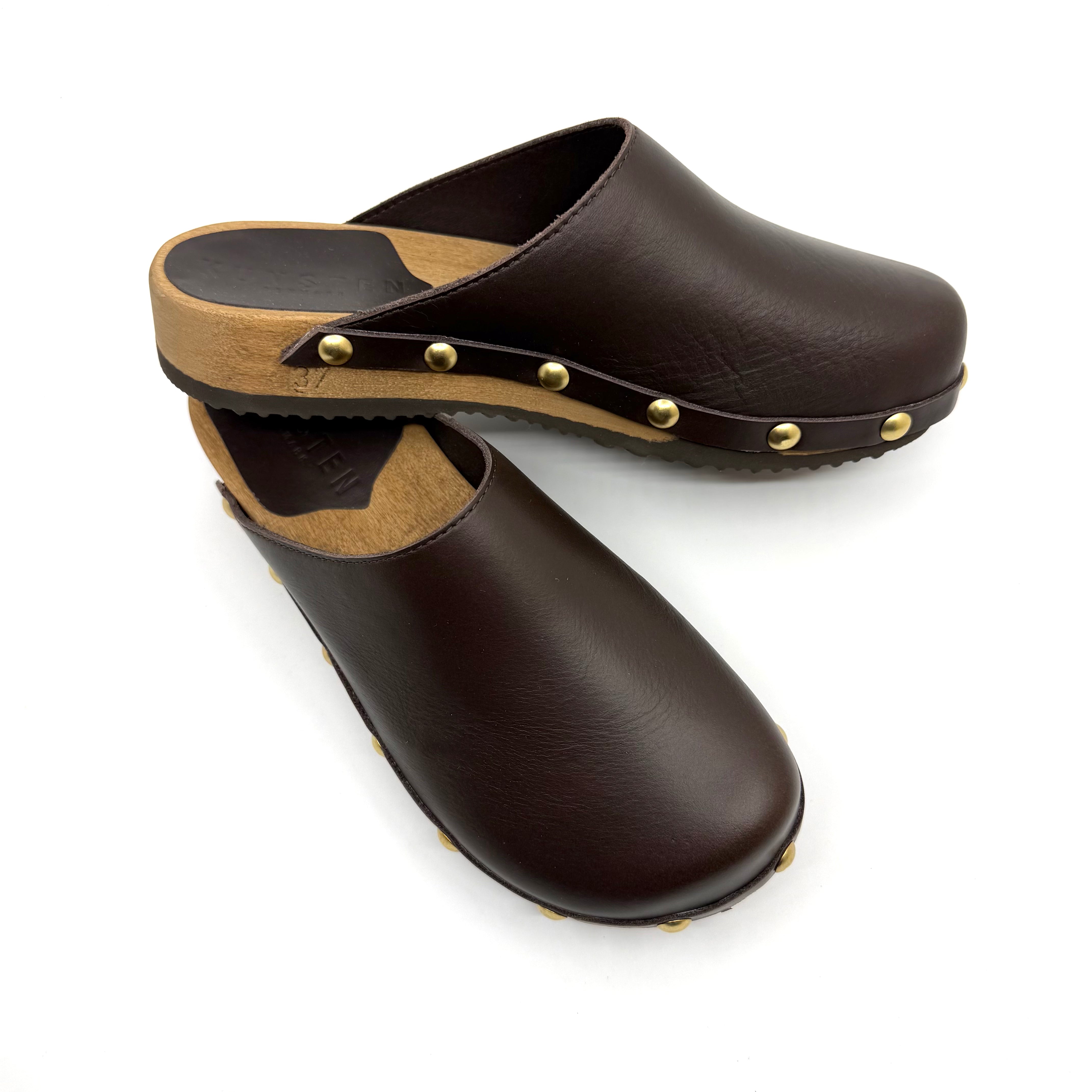 Pair of brown leather clogs with wooden sole on a white background