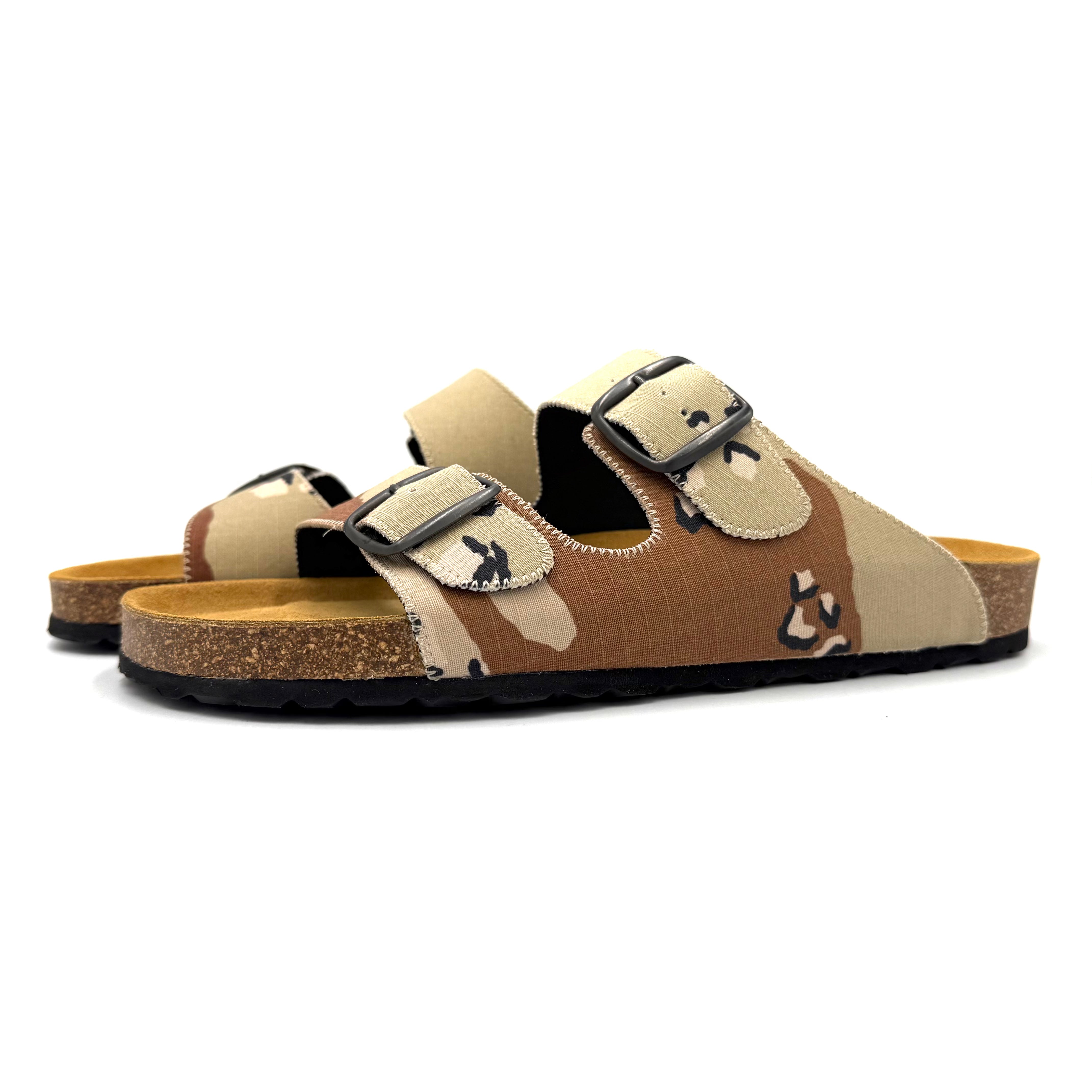 Pair of brown and beige sandals with black buckles on a white background