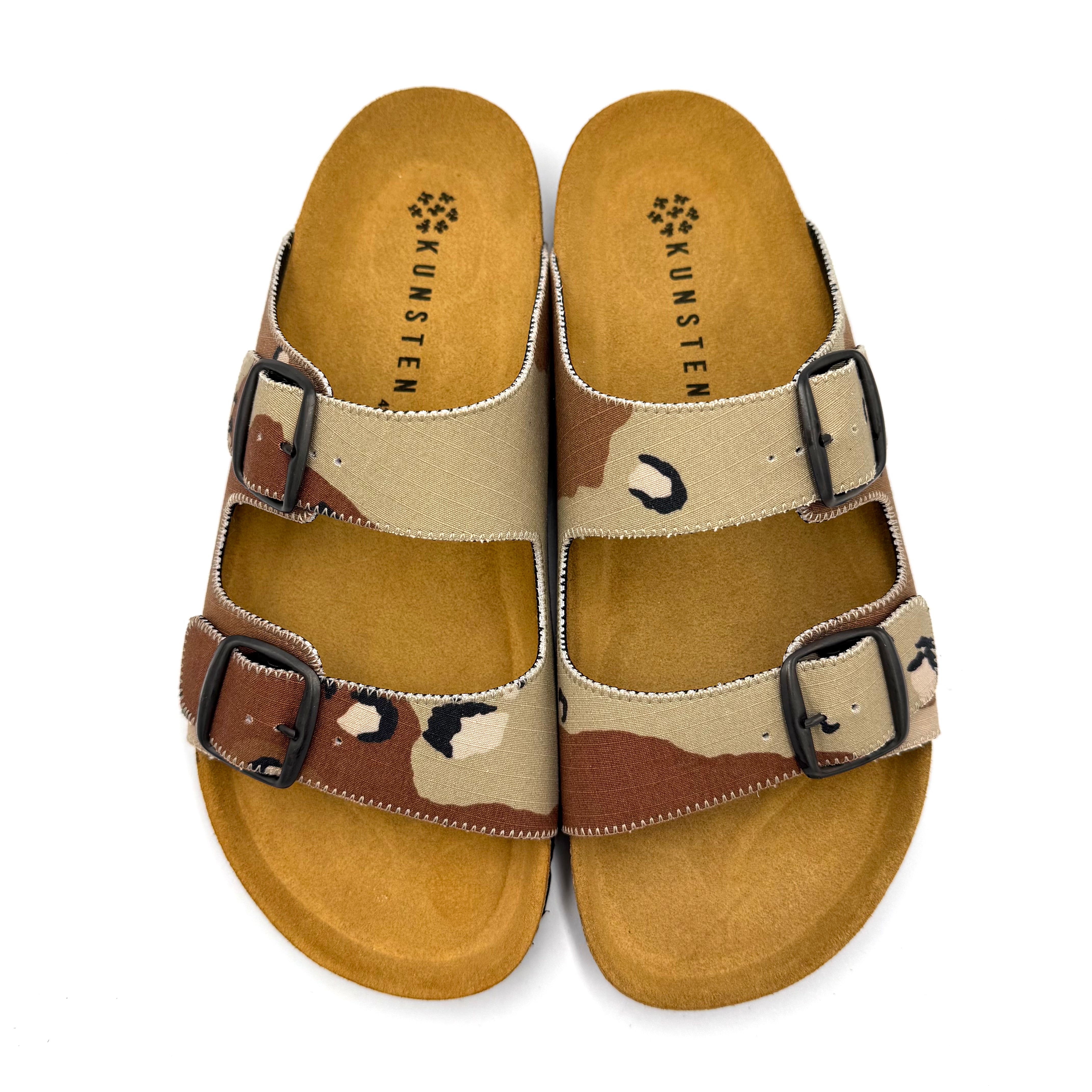 Camouflage-patterned sandals with black buckles on a white background