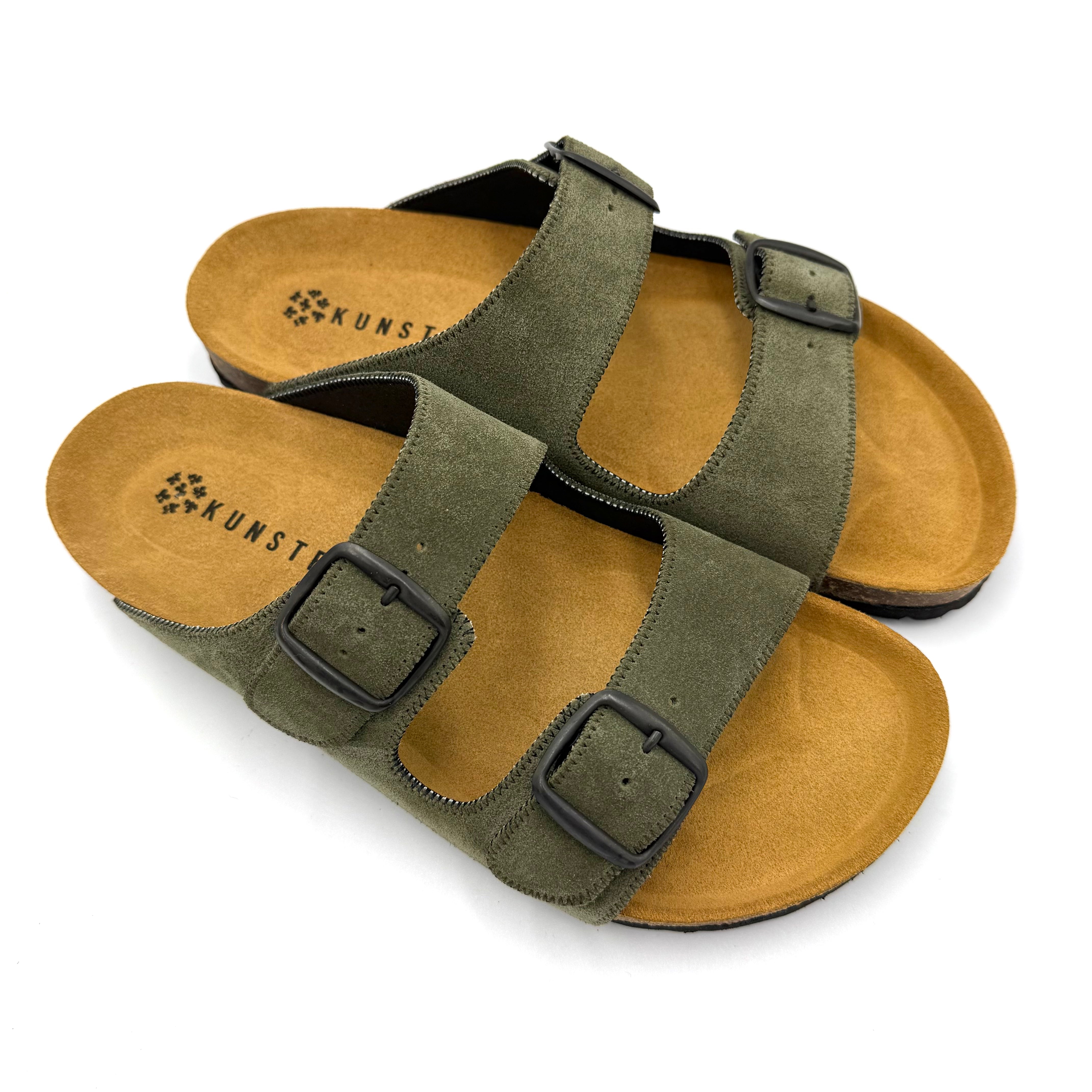 Pair of green sandals with brown soles on a white background