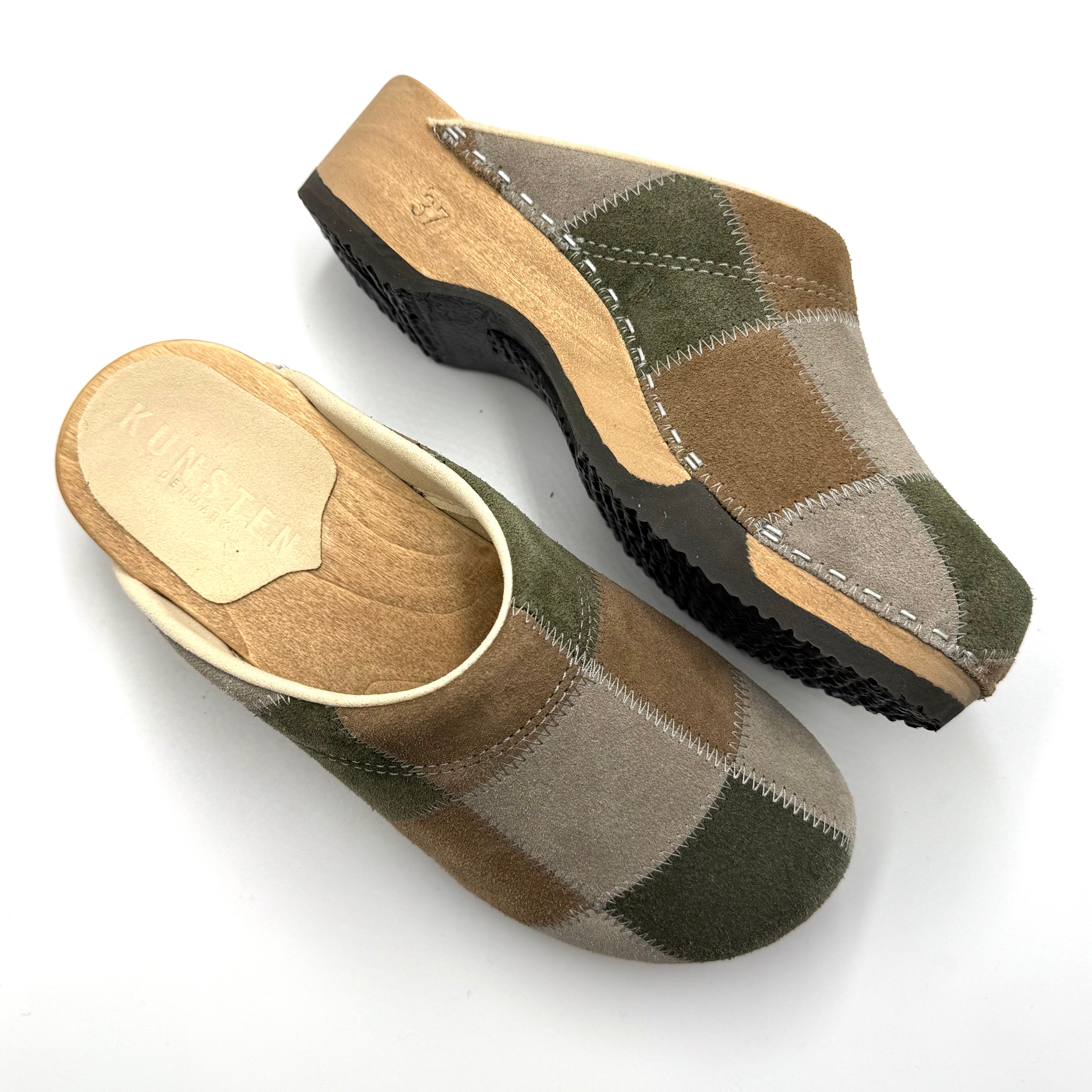 Pair of checkered slippers with wooden sole on a white background