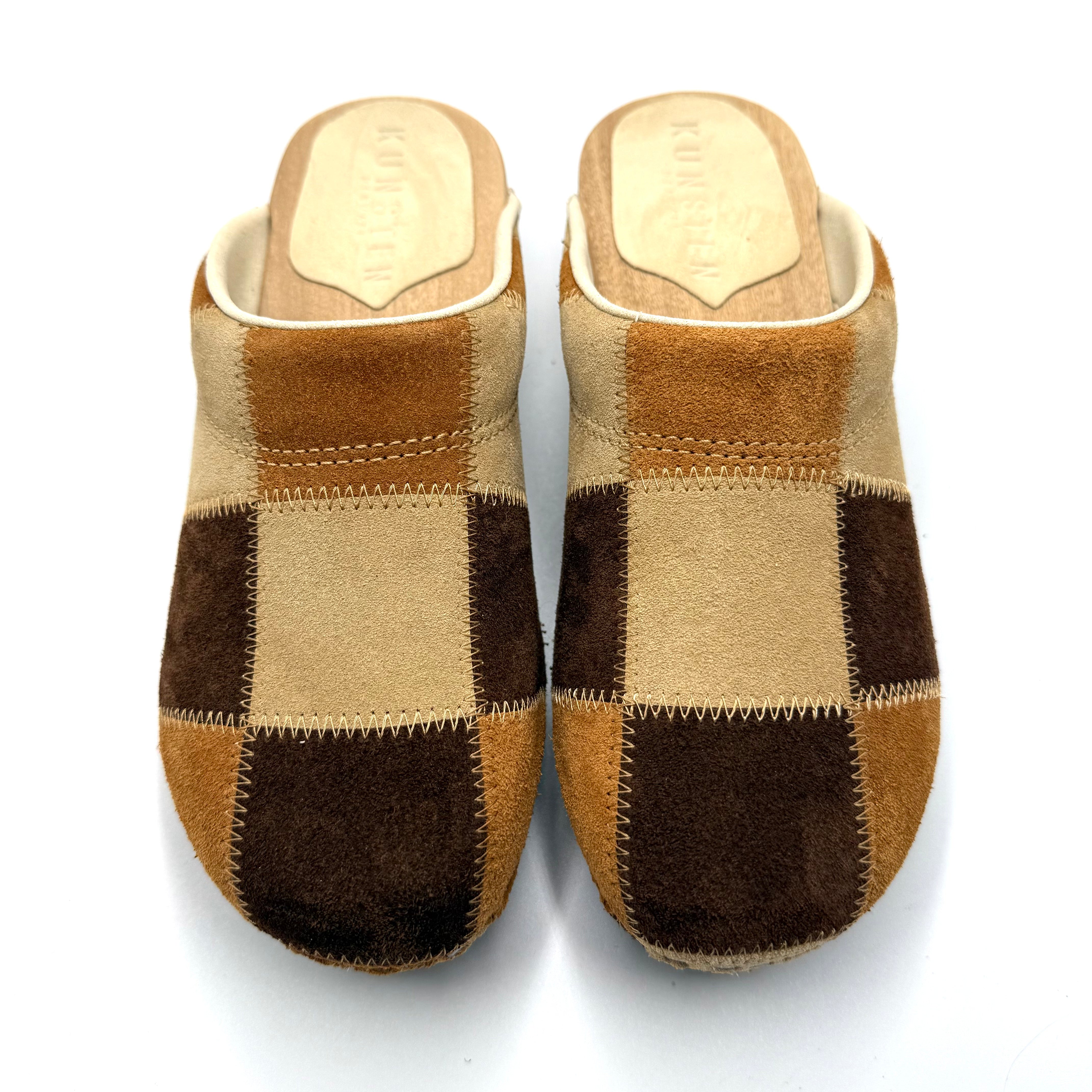 Pair of brown and beige checkered slippers on a white background
