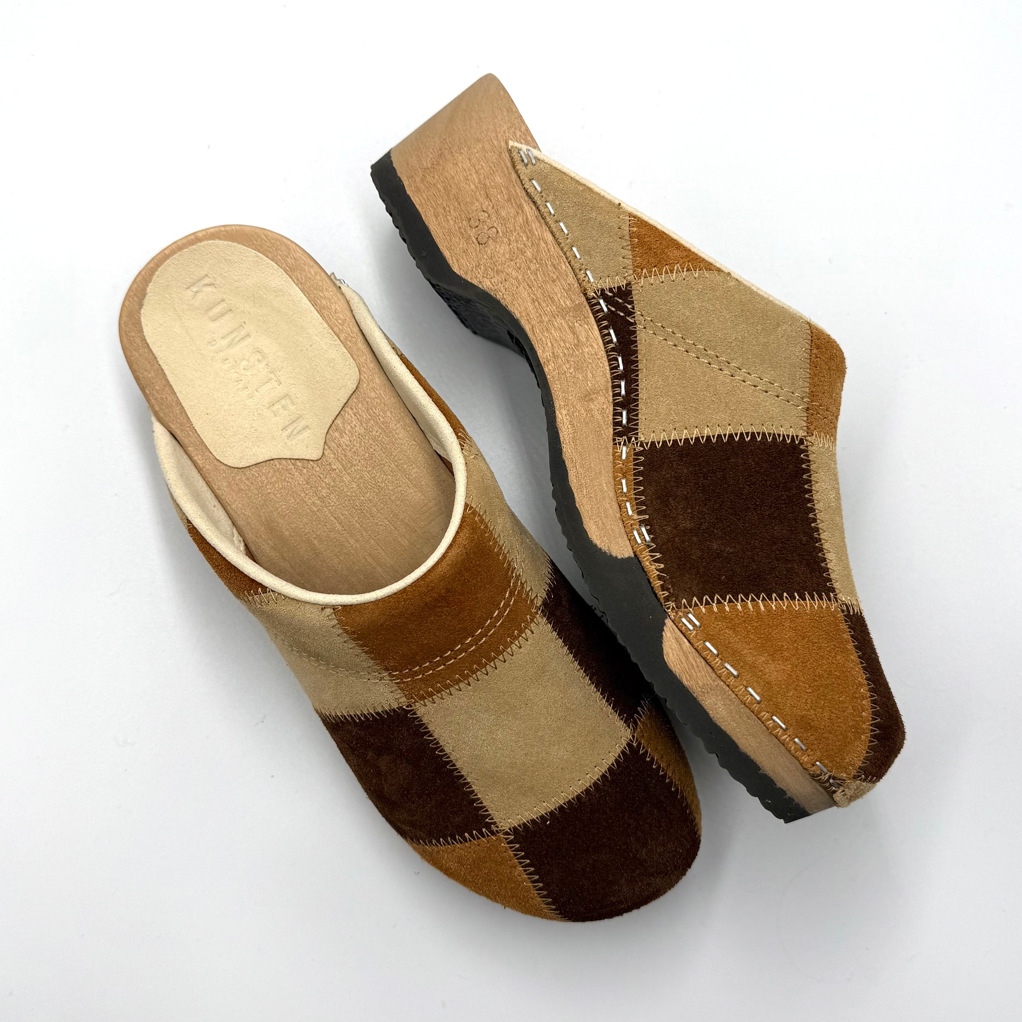 Pair of brown checkered mules on a white background