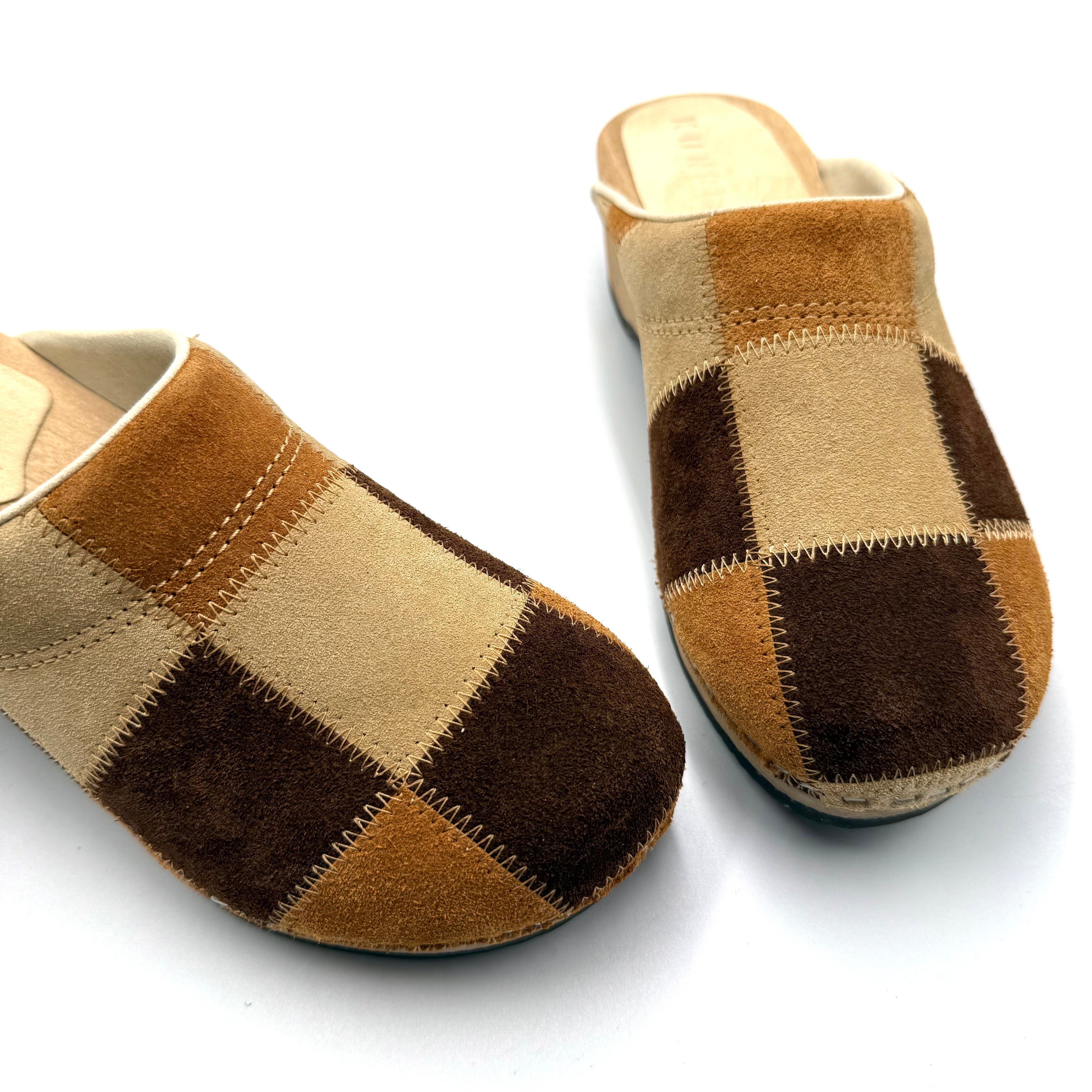 Pair of brown and beige checkered slippers on a white background