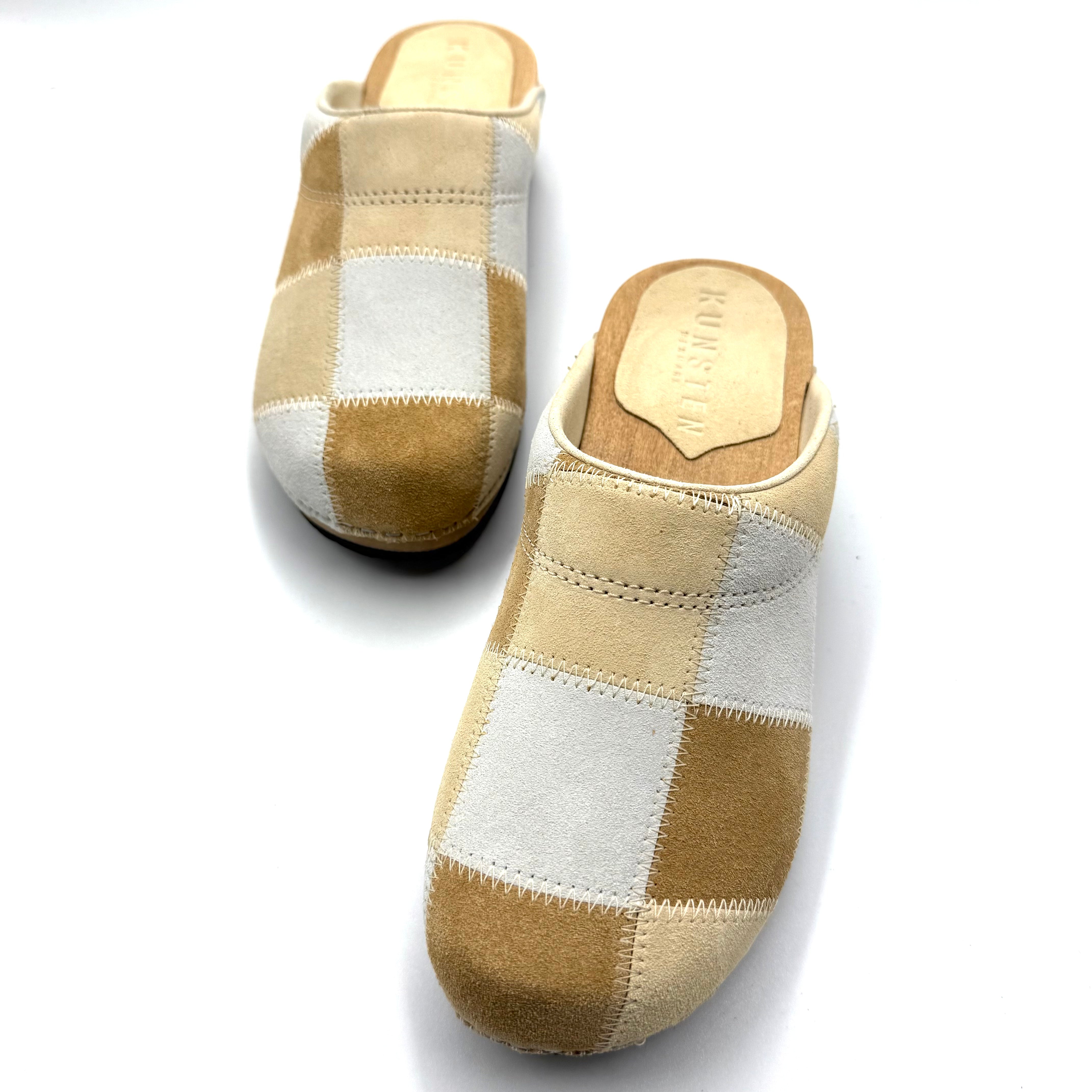 Pair of checkered slippers with wooden soles on a white background