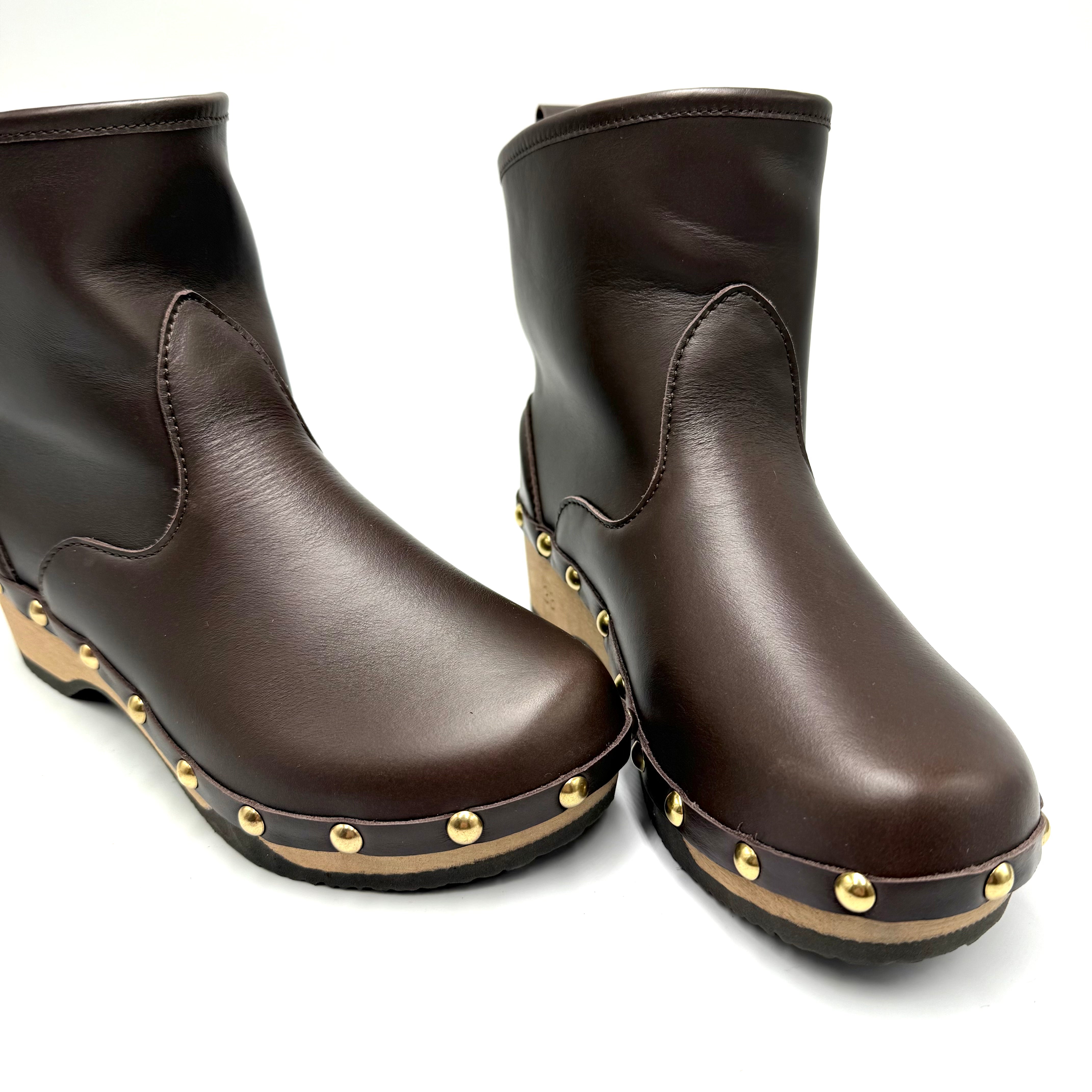 Pair of french rich brown leather studs boots on a white background