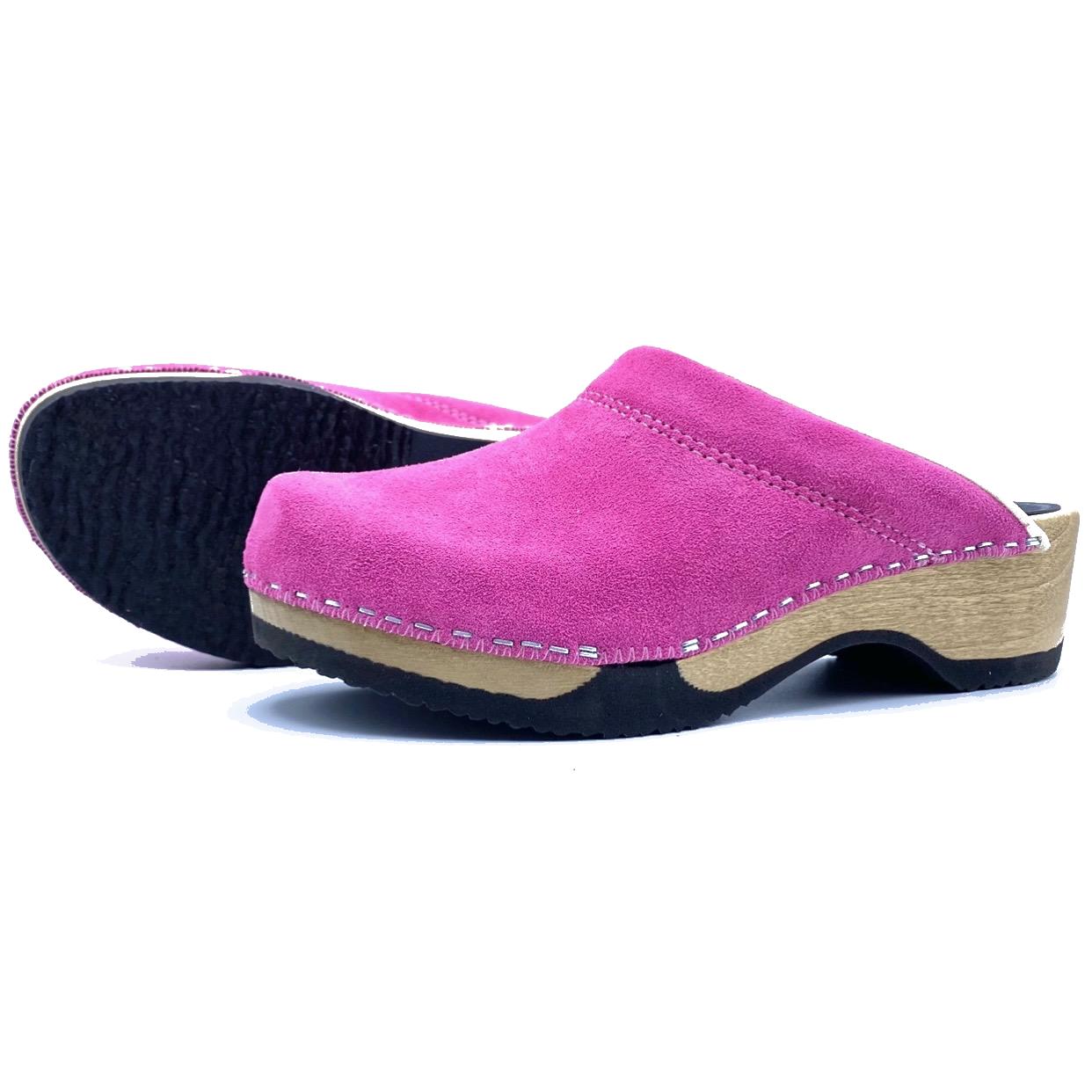 Pair of pink suede clogs on a white background