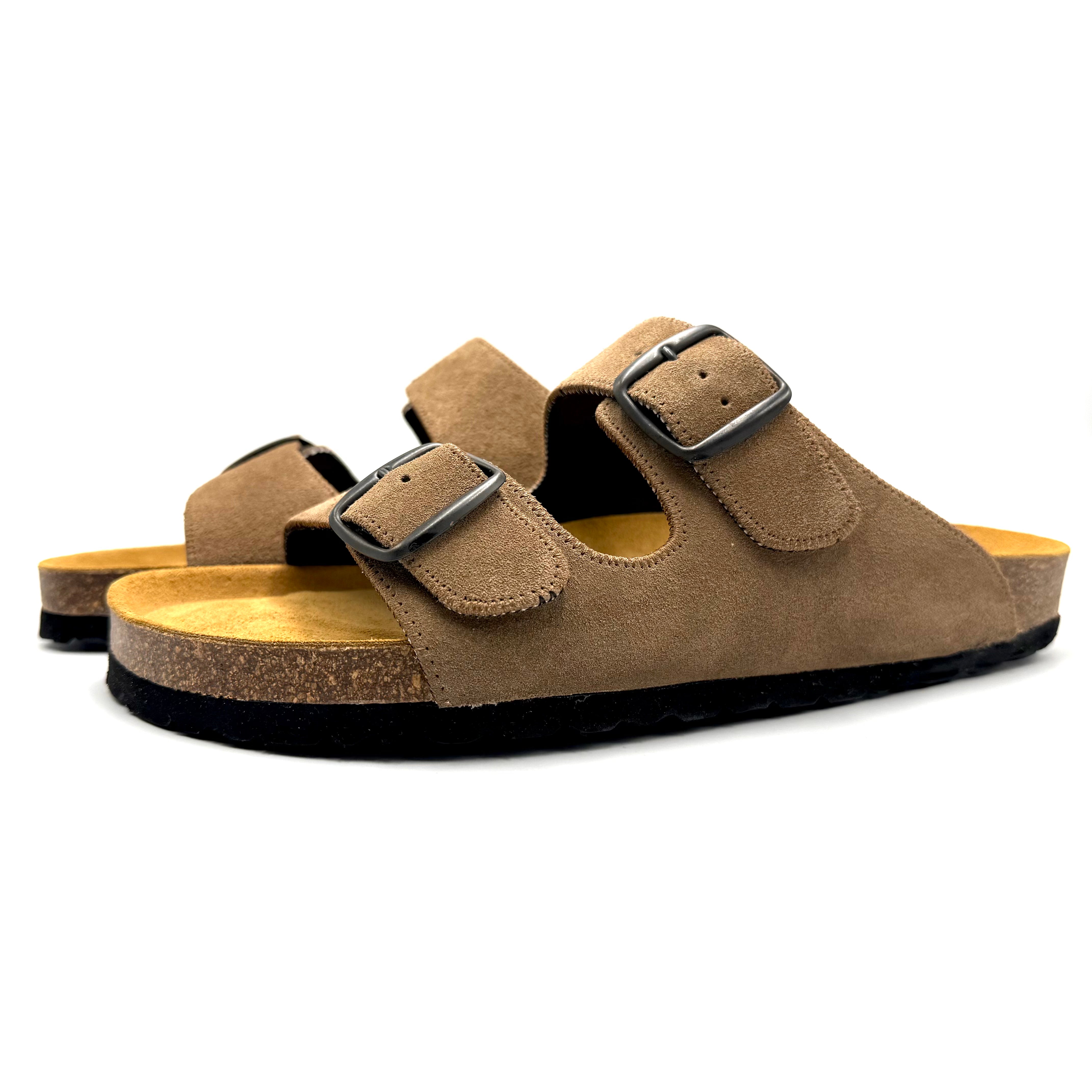 Pair of brown suede sandals with black buckles on a white background