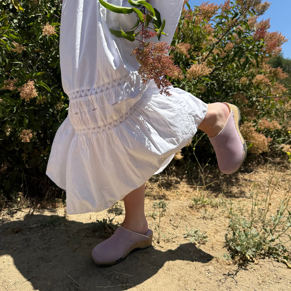 Pair of mauve clogs with wooden soles on a white background
