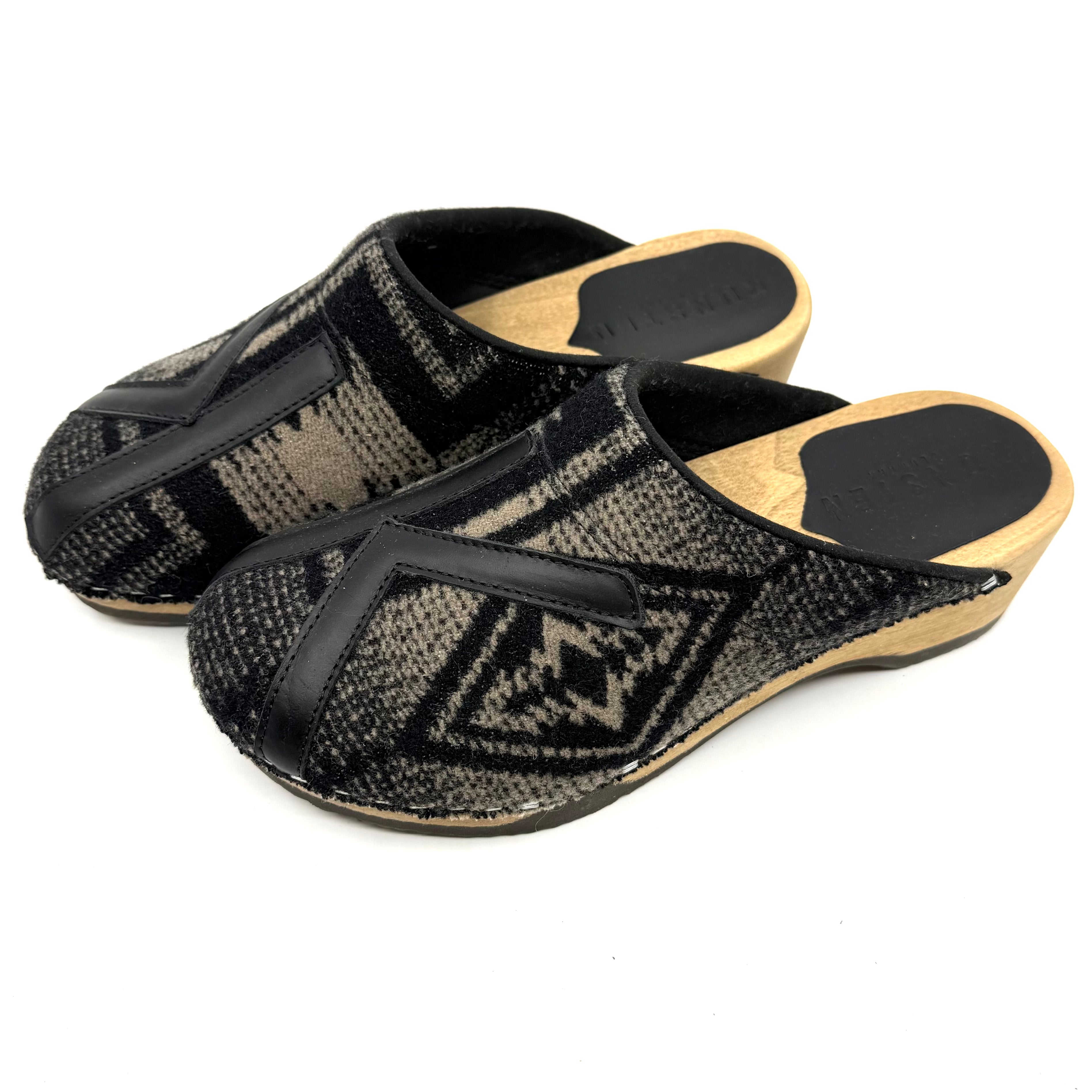 Pair of black and brown patterned sandals with wooden soles on a white background