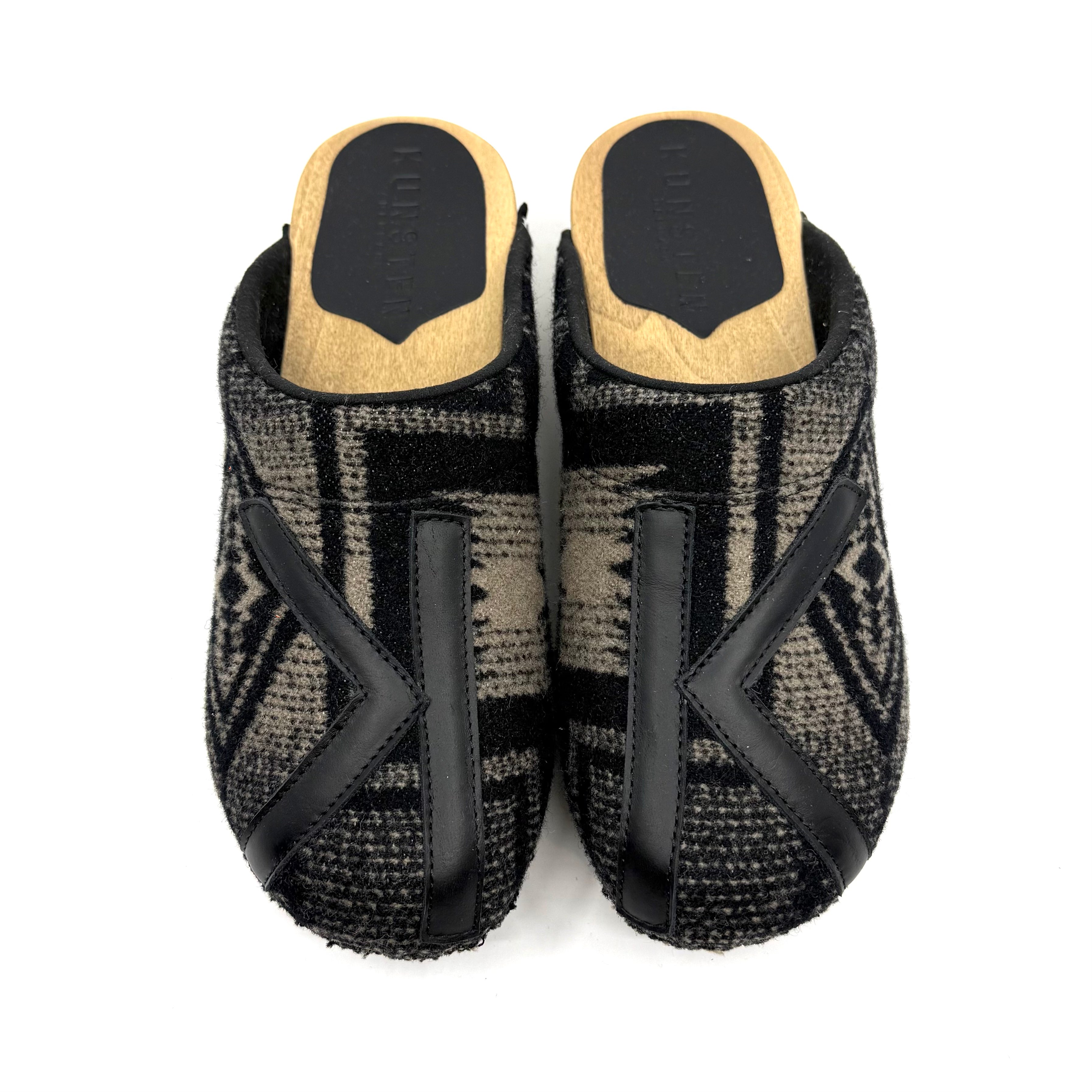 Pair of black and gray patterned slippers with wooden soles on a white background