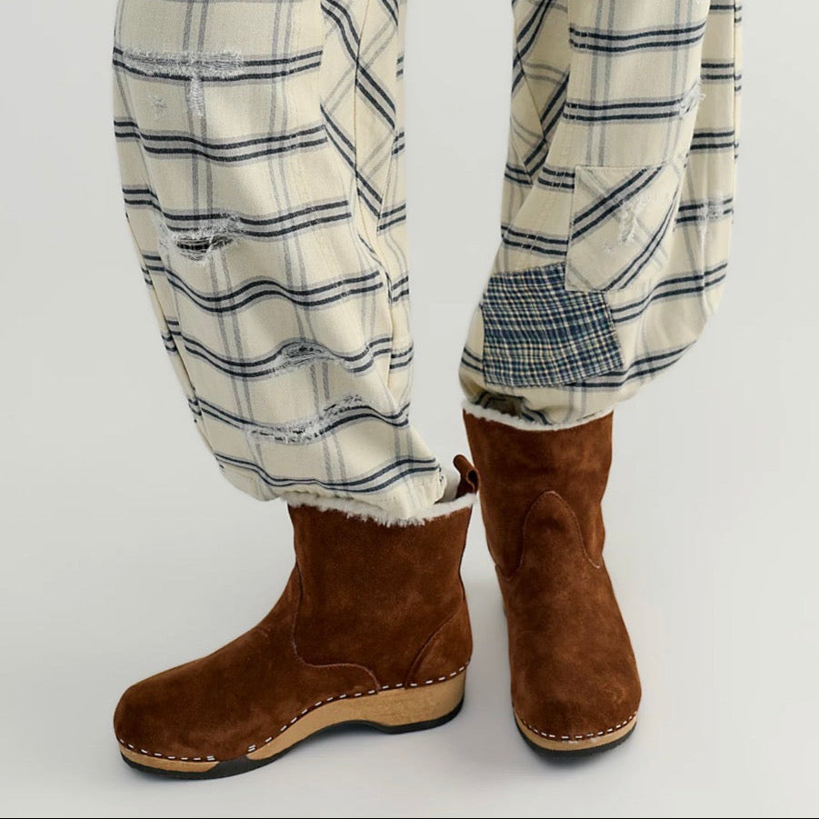 Brown suede boot with wooden sole on a white background