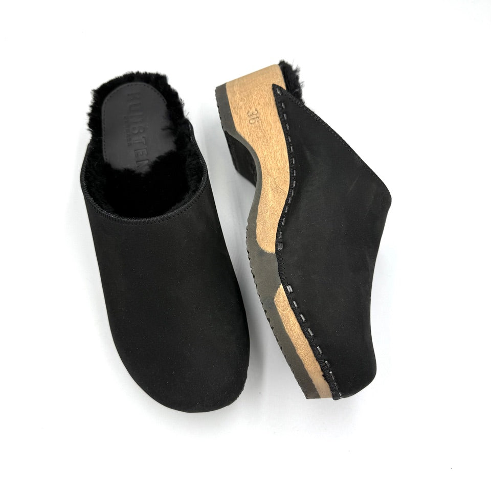 Black clogs with wooden sole on a white background