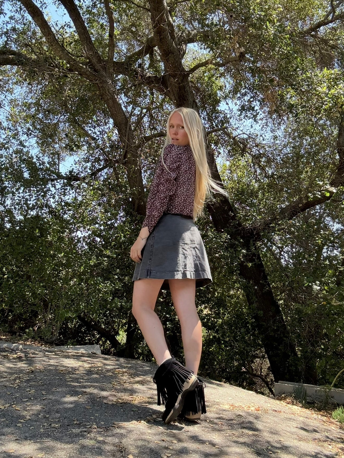 Woman standing outdoors with trees in the background