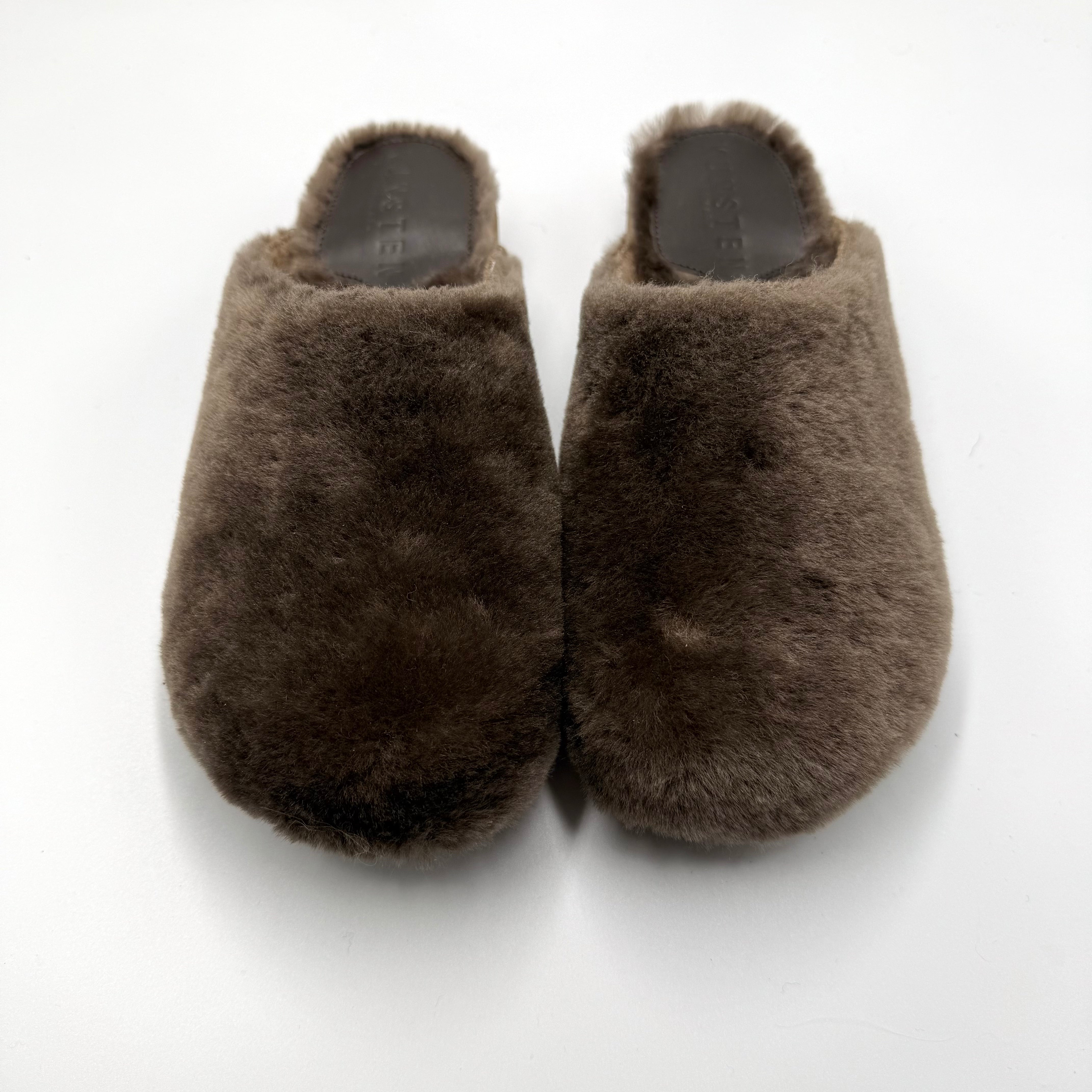 A pair of brown lambswoo cashmere slip-on slippers photographed from above on a plain white background.