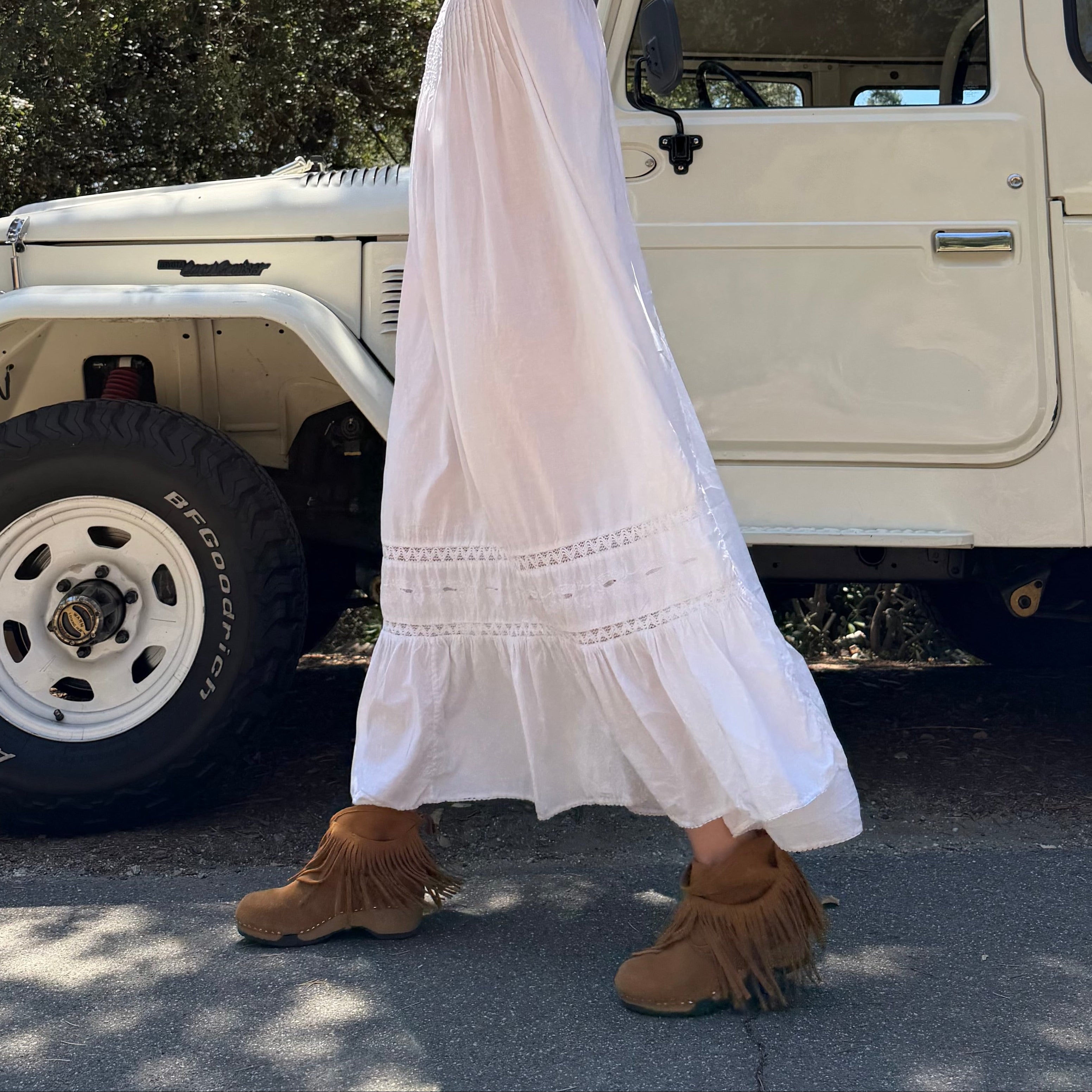 Pair of brown suede boots with fringes on a white background