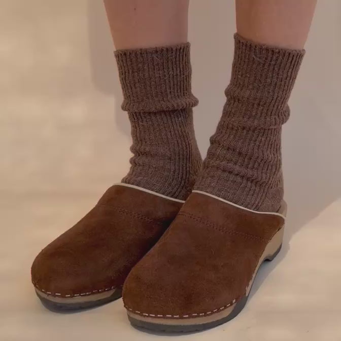 a person moving and bending KUNSTEN brown suede clogs 
